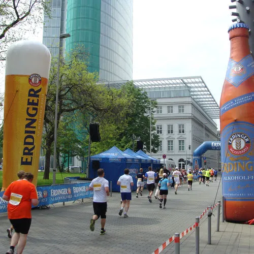 Überlebensgroße aufblasbare Erdinger Flasche und Weizenglas an der Laufstrecke eines Stadtmarathons