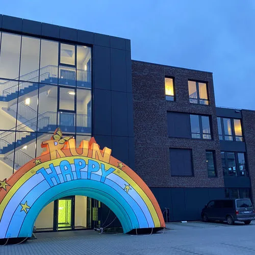 „Run Happy“ Regenbogen-Torbogen bei Dämmerung