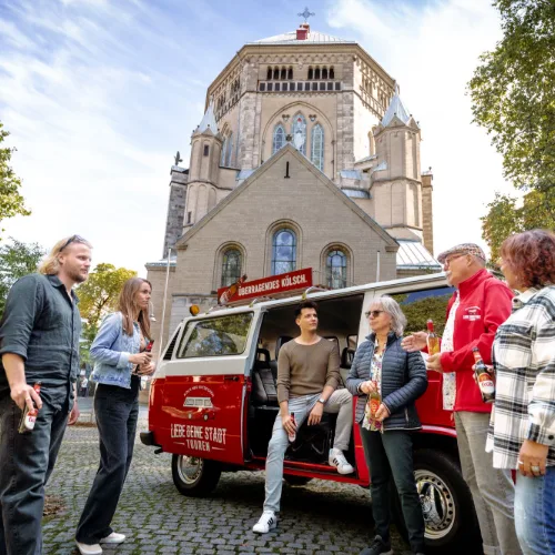 Tourgruppe vor einer romanischen Kirche in Köln
